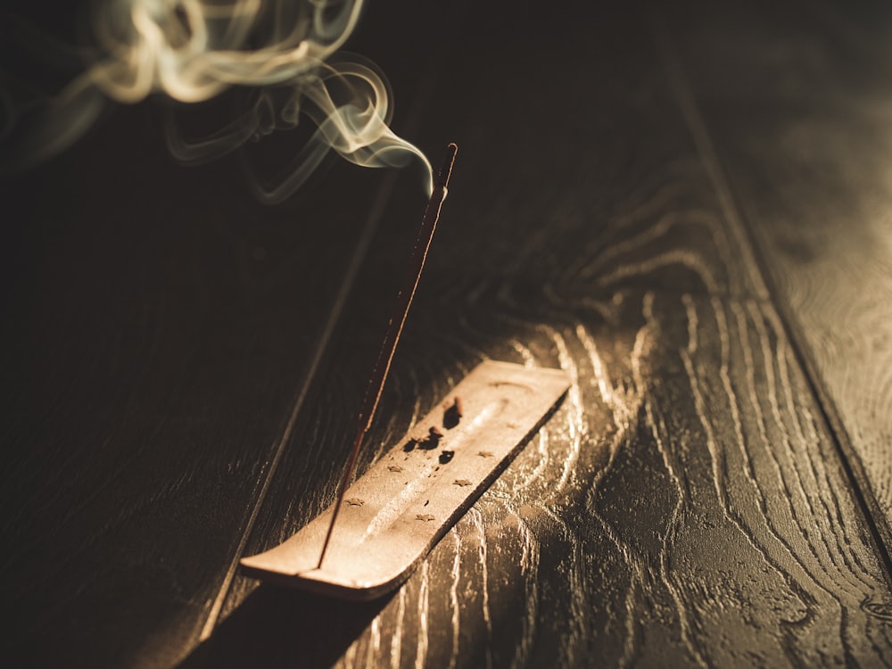 Incense sticks resting on dark wood in warm afternoon light