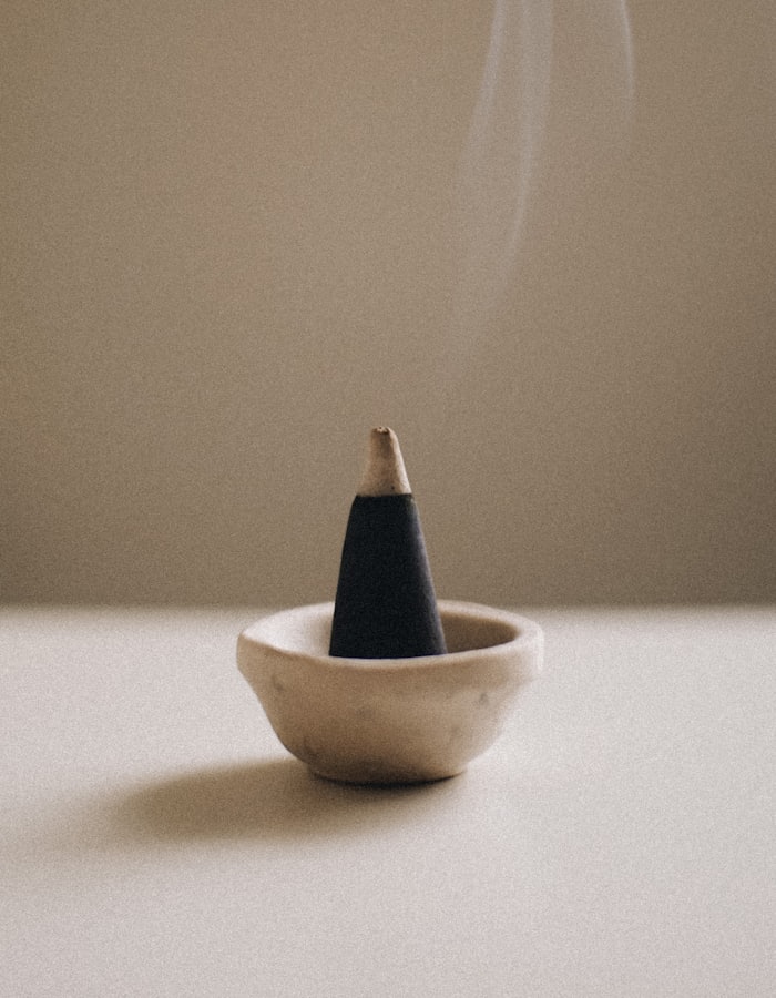 A dhoop cone burning, a thin ribbon of smoke rising